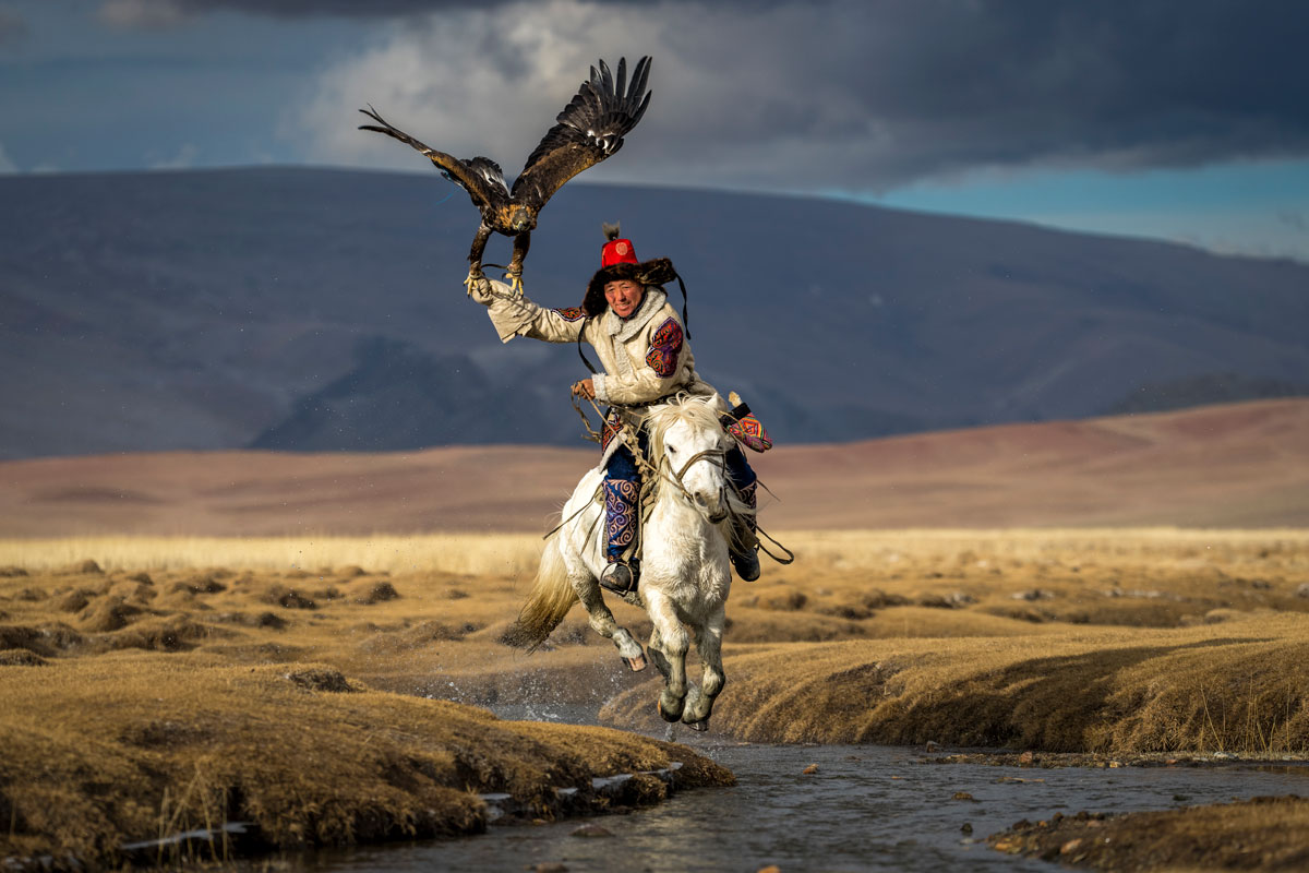 Asiilbek, a nomadic Kazakh eagle hunter, preps his golden eagle, Burged, for a horseback hunt in the grasslands outside of Bayan-Ölgii, the westernmost province of Mongolia. © Eric Esterle, Pictures of the Year 2022