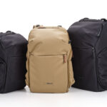 Three Shimoda backpacks side by side in different sizes with the left and right ones in black and the center one in a tan color, displayed against a white background.